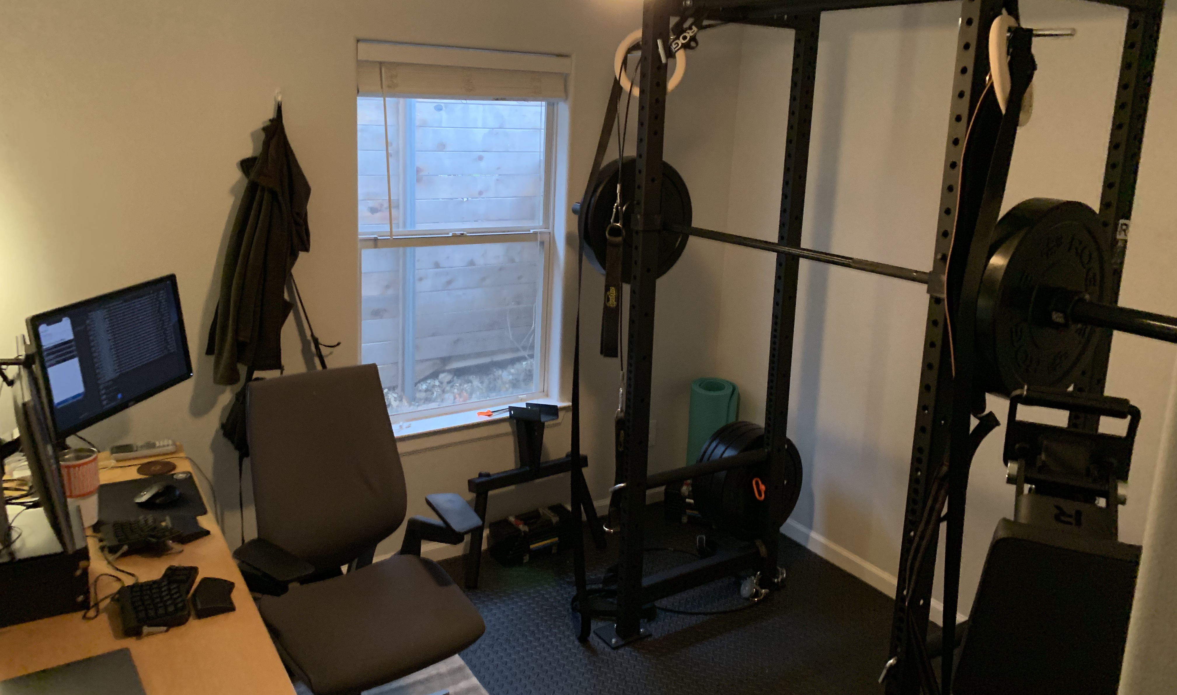 small room with squat cage and standing desk