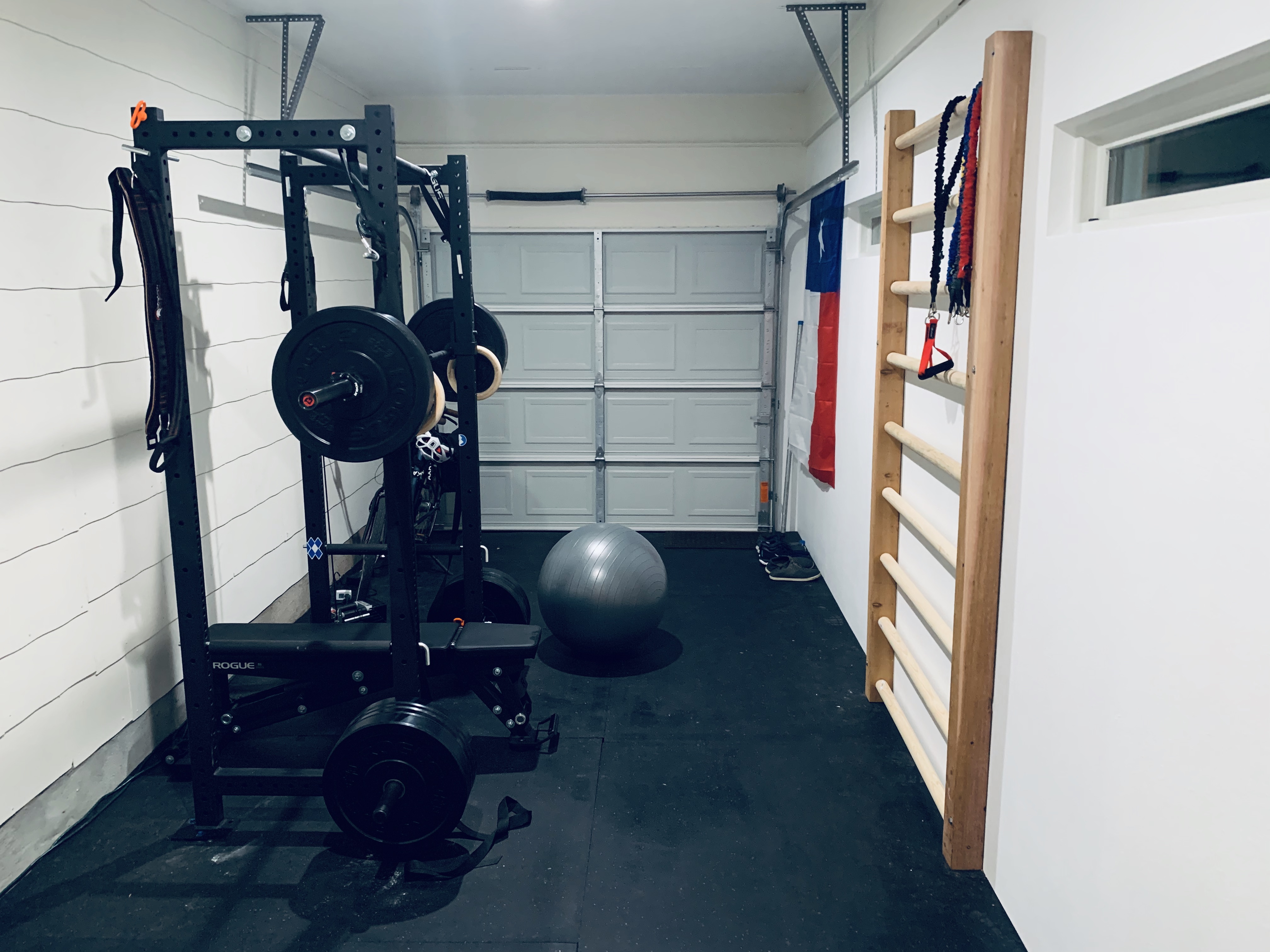 Big garage with squat cage, stall-bars, and Texas flag