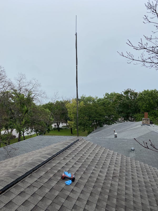A big antenna coming up out of a roof